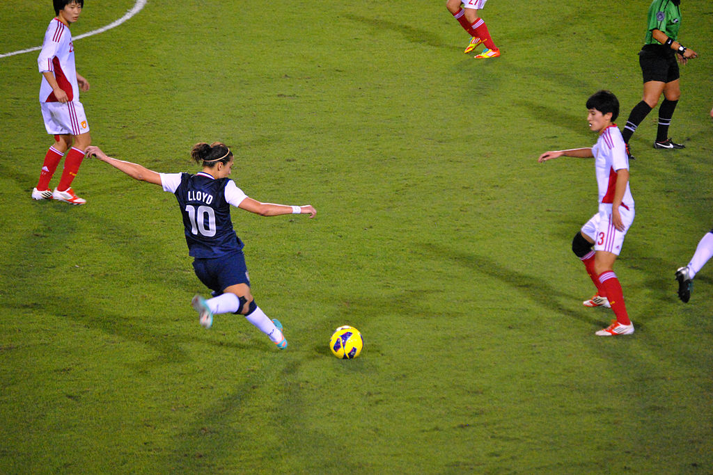 Carli Lloyd about to kick a soccer ball.