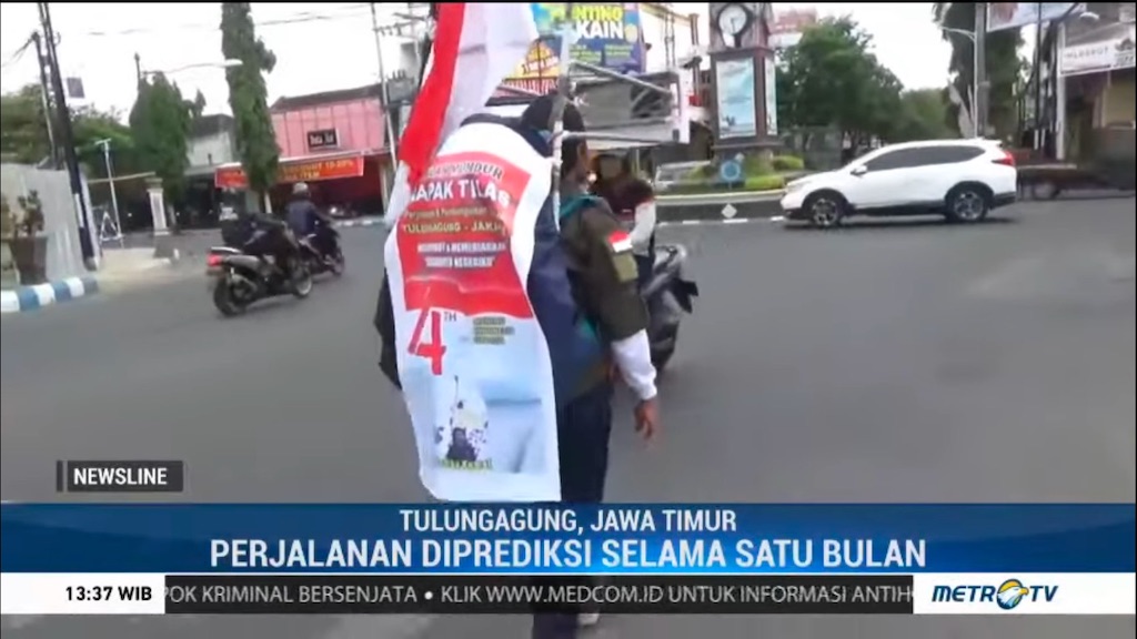 Medi Bastoni is shown walking backward through traffic in a screenshot from an Indonesian TV news program.