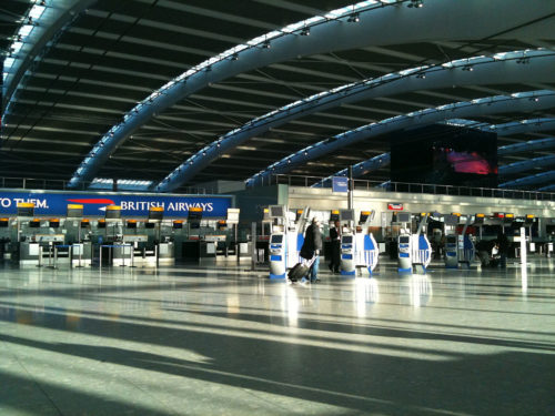 Nearly empty Heathrow Terminal 5 in 2010, with one woman walking, BA check-in counters in the background