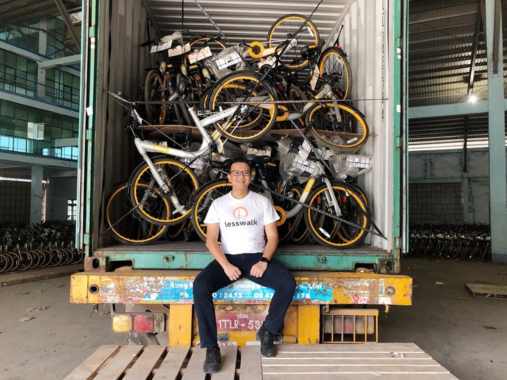 Mike Than Tun Win in front of a truck full of bikes.