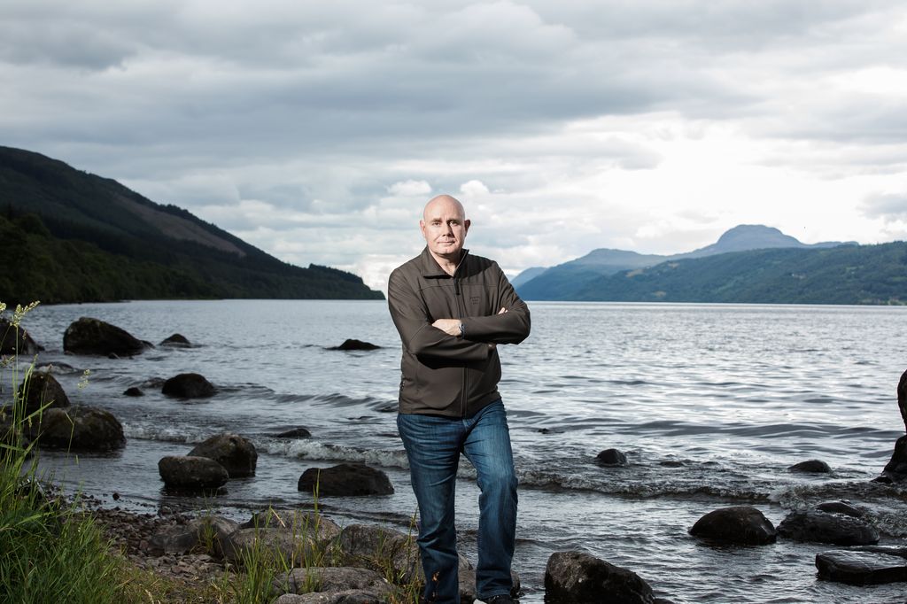 Portrait of professor Neil Gemmell beside Loch Ness, as seen on Beneath The Waves: Solving The Mystery of Loch Ness.