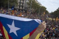 Catalan flag in foreground, peaceful protesters in the background
