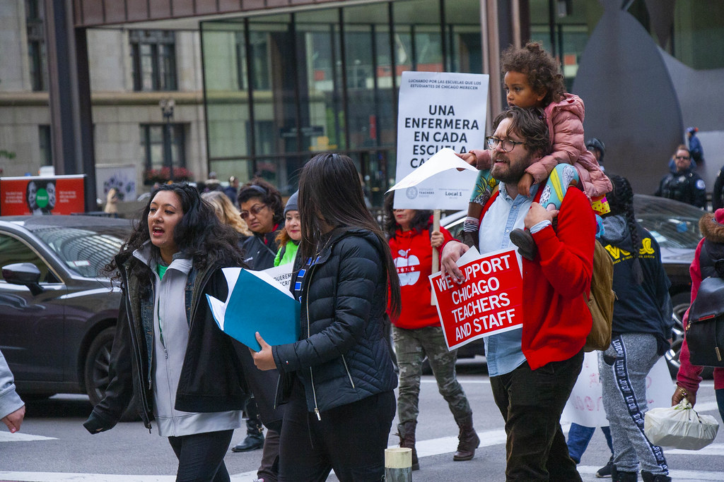 A family with a sign saying "We Support Chicago Teachers and Staff" Marches Through Downtown Chicago Illinois 10-17-19_3906