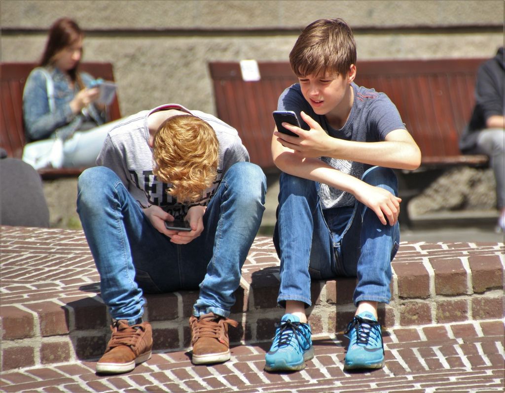 Two Boys Using Their Smartphones outside.