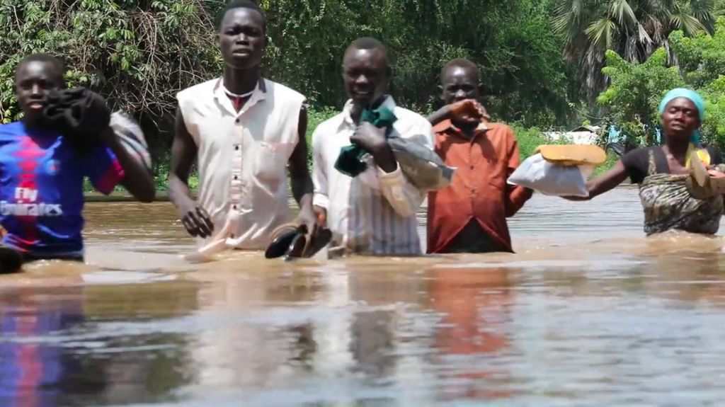 People walk through waist deep floodwaters in South Sudan.