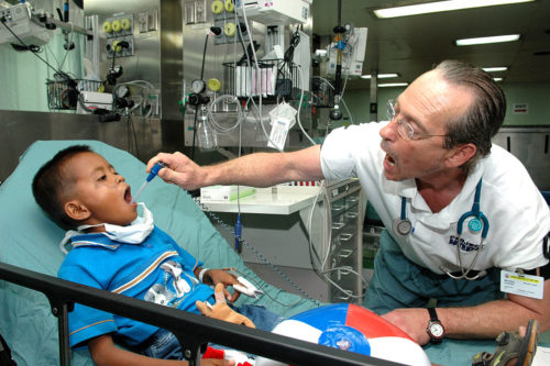 Tawi Tawi, Philippines (June 12, 2006) - Baltimore native Michael Foster, a Project HOPE (Health Opportunities for People Everywhere) volunteer, takes a child's temperature during the check-in process aboard the U.S. Military Sealift Command (MSC) Hospital Ship USNS Mercy