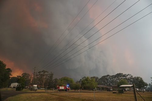 Fire and Rescue NSW firefighters move into Braddocks Road at Werombi to protect properties from the out of control Green Wattle Creek bushfire in South West Sydney