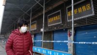 A pedestrian in a face mask walks past the Huanan Seafood Wholesale Market market in Wuhan, which was closed after a novel coronavirus was determined to originate there.