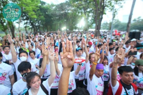 Runners raise their fingers in a three-finger salute at the Run Against Dictatorship in Bangkok.