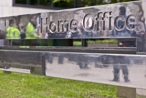 Home office sign with police reflected.