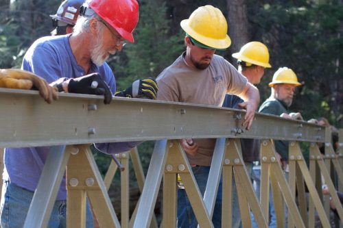 Local trail loving volunteers assemble and put into place a foot bridge across Pine Creek as part of the Bearfoot Trail project in Pine, AZ.