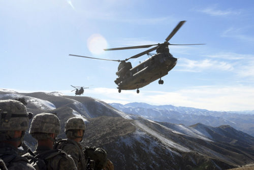 Soldiers with the 101st Division Special Troops Battalion, 101st Airborne Division watch as two Chinook helicopters fly in