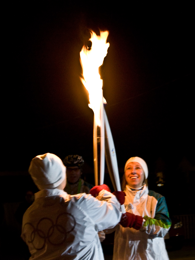 The Olympic Flame passes from one torch to another as part of the Vancouver winter Olympics in 2010.