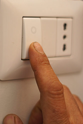 Finger turning off a switch.