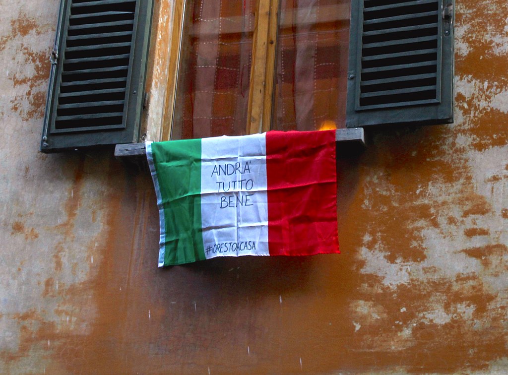 An Italian flag hung outside of a window in Bologna with the slogan "Andrà tutto bene" (Everything is gonna be fine) during the Covid-19 pandemic in 2020. (#iorestoacasa: #istayathome)