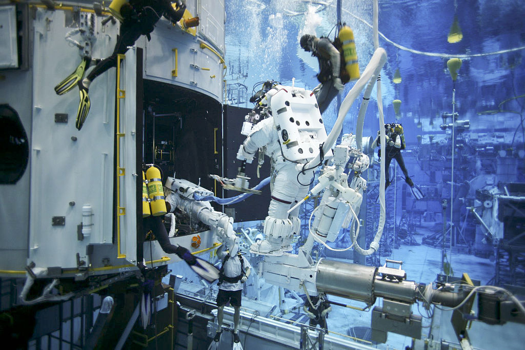 Servicing Mission 4 astronauts practice on a Hubble model underwater at the Neutral Buoyancy Lab in Houston under the watchful eyes of NASA engineers and safety divers