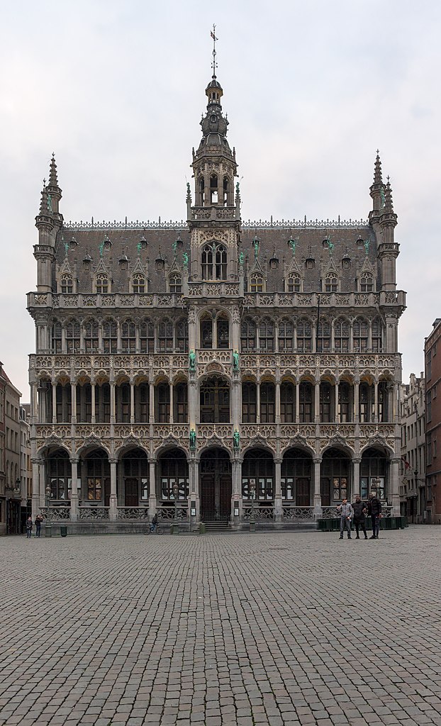 Three people posing in front of the Brussels City Museum while Grand Place is unusually empty because of the COVID-19 pandemic
