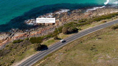 Picture of an ambulance on a highway by the sea.