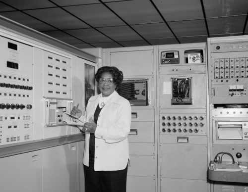 Mary Jackson standing with notes in front of a computing machine at NASA Langley