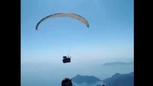 View of Hasan Kaval's couch flying, suspended from a paraglider.