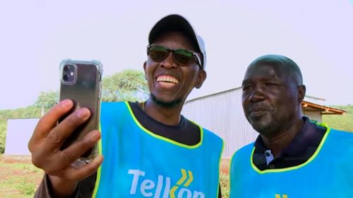 People from Telkom Kenya look at a cell phone getting service from a Loon balloon.