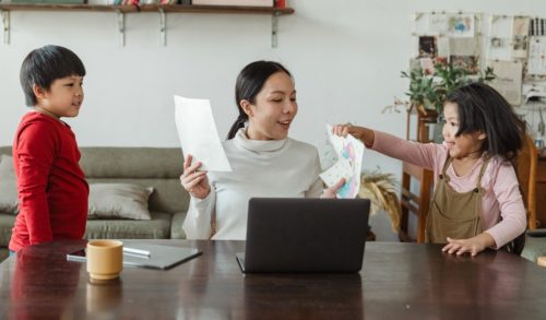 Modern working mother looking at pictures of kids at home