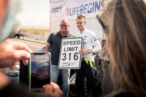 SSC leader Jerod Shelby (left)  and driver Oliver Webb (right), holding a sign saying, "Speed Limit 316".