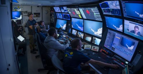 Scientists on board the Falkor monitor the underwater robot on a panel of screens.