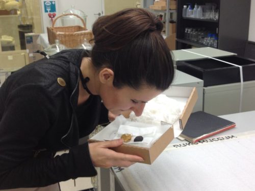 Researcher Caro Verbeek smelling a pomander - two small objects in a carefully packaged box.