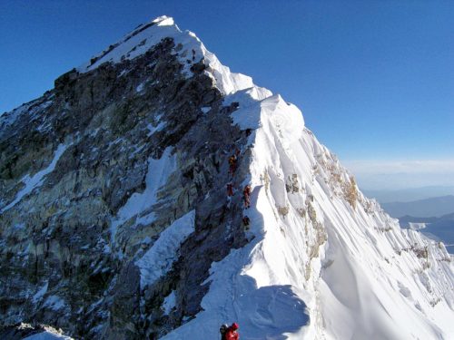 View upward along the southeastern ridgeline, the Hillary Step is visible. The top of the South-West face is on the left in shadow, and in the light to the right is the top of the East/Kangshung face.