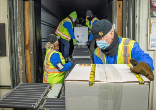 UPS workers load boxes of the Pfizer coronavirus vaccine to be shipped.