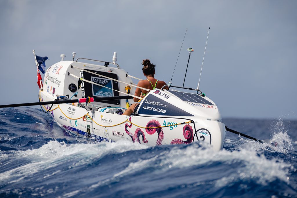 Jasmine Harrison rowing her boat in slightly choppy waters.