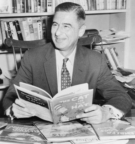 Ted Geisel (Dr. Seuss) half-length portrait, seated at desk covered with his books / World Telegram & Sun photo by Al Ravenna.