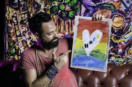 Sacha Jafri holds up one of the drawings sent in to him by children describing their feelings during the pandemic.