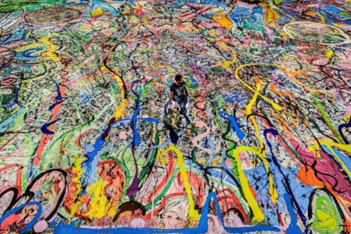 Sacha Jafri stands on his massive painting, The Journey of Humanity, in July of 2020.