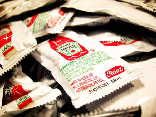 A pile of Heinz Tomato Ketchup packets.
