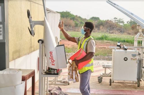 A Zipline worker loads Covid-19 vaccines into a drone for delivery.