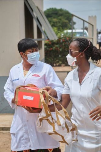 Medical workers collect a package dropped by a Zipline drone.