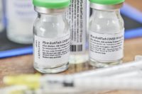 Closeup of two glass vials of Pfizer/BioNTech vaccine.