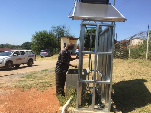 A man washes his hands at a new solar hot water station at a health clinic in eSwatini.