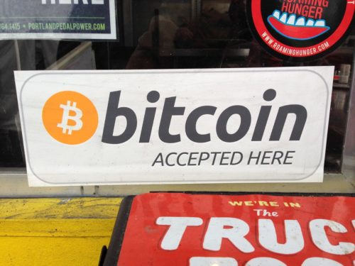 A picture of a window with a decal saying 'Bitcoin accepted here.'