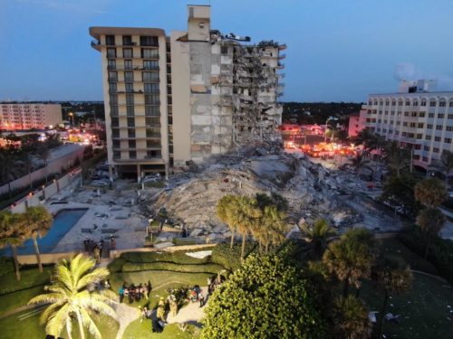 View of the partially collapsed Champlain Towers South condo building, with rescue workers visible on the ground.