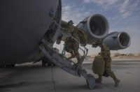 Aircrew assigned to Al Udeid Air Base, Qatar, carry their gear into a C-17 Globemaster III assigned to Joint Base Charleston, South Carolina, April 27, 2021, at Al Udeid AB. U.S. Air Force C-17s and other mobility aircraft around the U.S. Air Forces Central theater are assisting with the safe and orderly drawdown operations from Afghanistan