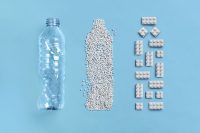 A plastic bottle, granulated PET in the shape of a bottle, LEGO bricks made from recycled PET in the shape of a bottle.
