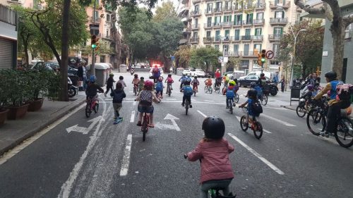 Kids biking to school in a bicibús in L'Eixample Barcelona, Spain.