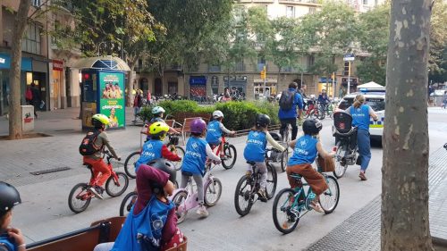 Kids biking to school in a bicibús in L'Eixample Barcelona, Spain.