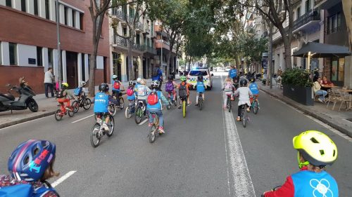 Kids biking to school in a bicibús in L'Eixample Barcelona, Spain.