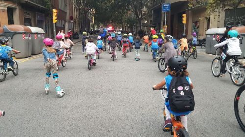 Kids biking to school in a bicibús in L'Eixample Barcelona, Spain.