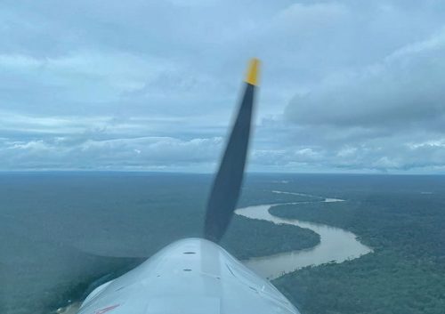 Looking out across the prop at a river winding through the jungle as Zara Rutherford flies into Panama.