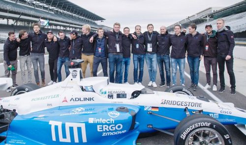 Indy Autonomous Challenge: The winning team, TUM Autonomous Motorsport poses  behind their self-driving car.